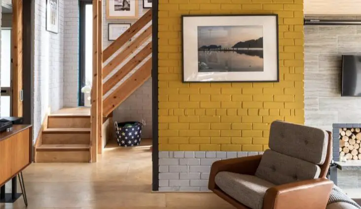 idée peinture mur en briques couleur jaune gris salon moderne et élégant fauteuil bicolore