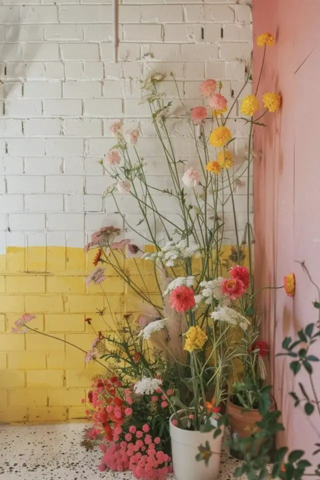 peinture mur en brique intérieur soubassement trashwall jaune et blanc mur adjacent rose ambiance bucolique champêtre fleur sol terrazzo 