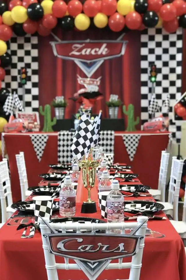 déco anniversaire enfant thème voiture table et décor de la maison dessin animé Cars Pixar nappe rouge assiette noir et blanche trophée et drapeau de course idée originale 