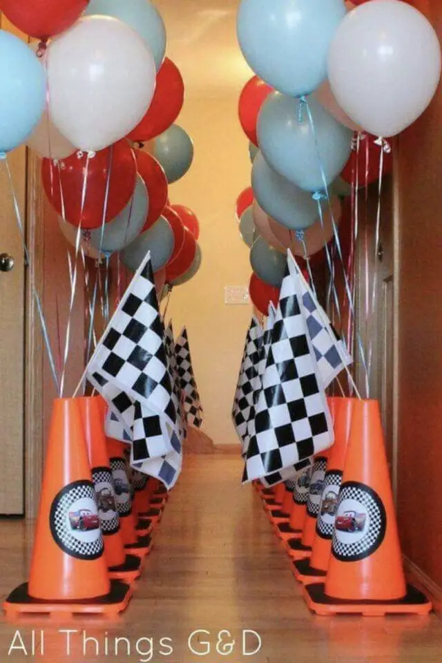 déco anniversaire enfant thème voiture cône de signalisation orange pour suspendre des ballons bleu blanc rouge drapeau de course idée pour décorer le couloir 