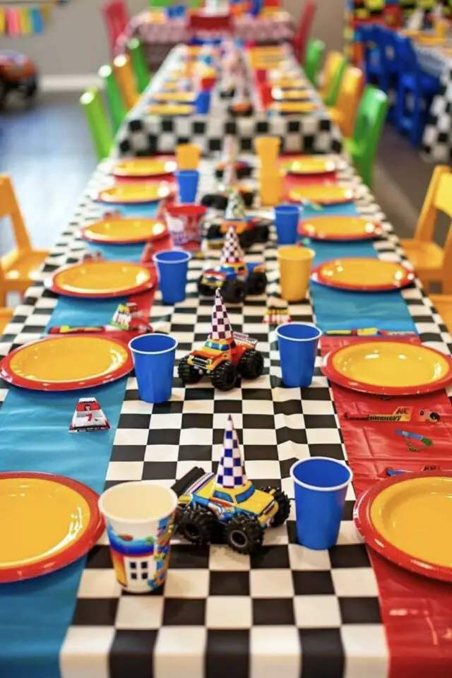 exemple anniversaire enfant thème voiture décoration table goûter nappe à damier noir et blanc chemin de table rouge et bleu assiette jaune gobelet coloré petit jouets idée simple et colorée