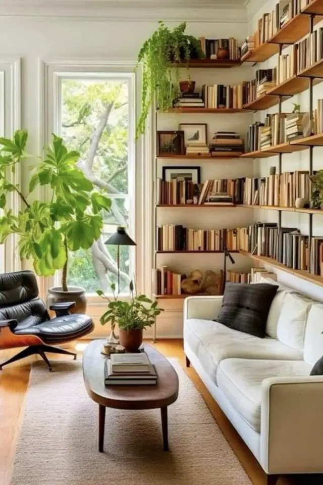 jolie décoration de salon photo canapé beige 4 places étagères murales bibliothèque plante verte fauteuil design Eames années 50 tapis beige table basse bois foncé 
