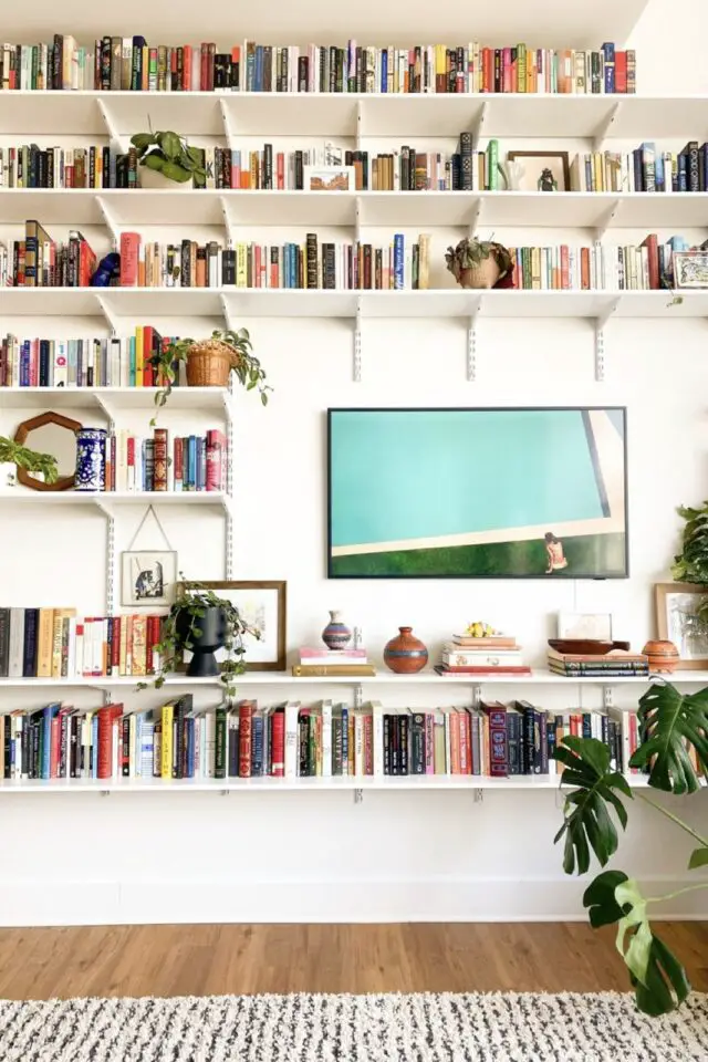 jolie décoration de salon mur rangement bibliothèque étagère en ton sur ton plantes vertes chic et design 