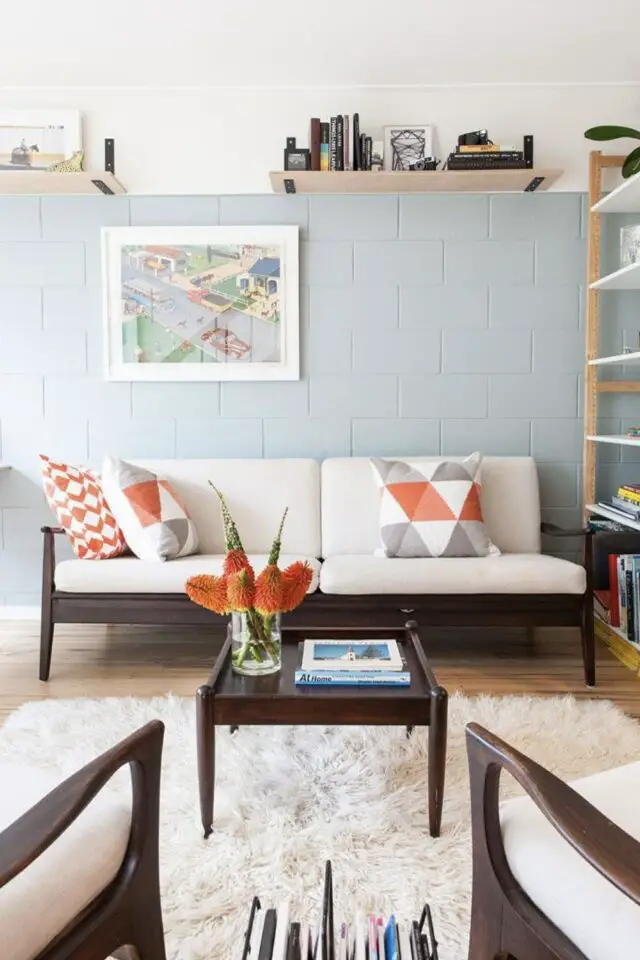 mur intérieur en parpaings bruts sans enduit peinture soubassement bleu et blanc pastel douceur salon séjour canapé noir et écru tapis poil long étagères en bois mur intérieur en parpaings bruts sans enduit peinture soubassement bleu et blanc pastel douceur salon séjour canapé noir et écru tapis poil long étagères en bois