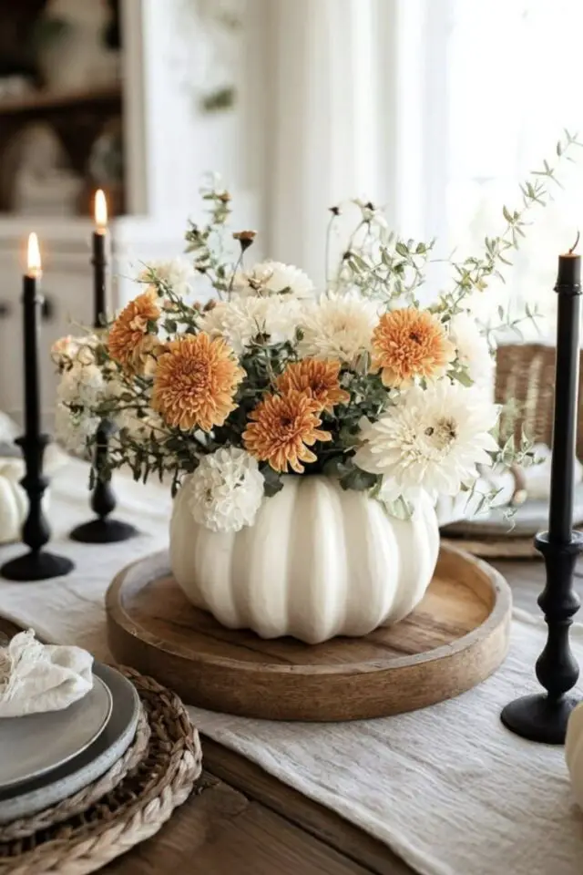 décoration halloween chic citrouille et fleurs blanc et orange composition florale simple et élégante centre de table plateau en bois rustique bougie chandelles noires 