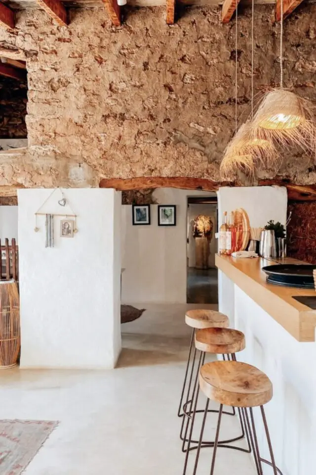déco Ibiza chic cuisine ouverte mur blanc et pierre naturelle plan de travail snack en bois tabouret rond suspension en bambou tressé déco Ibiza chic cuisine ouverte mur blanc et pierre naturelle plan de travail snack en bois tabouret rond suspension en bambou tressé