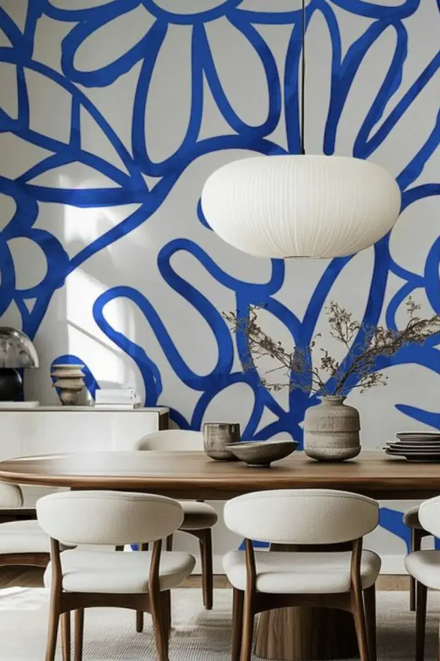 tendances déco 2026 salle à manger papier peint graphique bleu et blanc motif XXL table ovale en bois chaise douillette dossier enveloppant tendances déco 2026 salle à manger papier peint graphique bleu et blanc motif XXL table ovale en bois chaise douillette dossier enveloppant