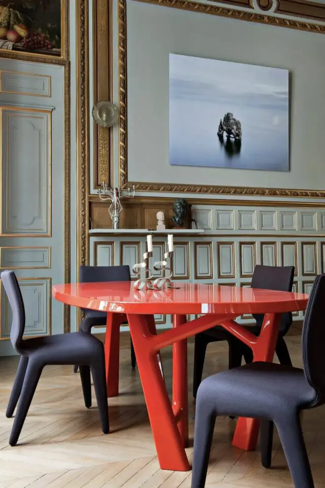 tendances déco 2026 salle à manger design mur ancien moulure or et bleu grisé table rouge chaise esthétique contemporaine contraste laque brillante et mate tendances déco 2026 salle à manger design mur ancien moulure or et bleu grisé table rouge chaise esthétique contemporaine contraste laque brillante et mate