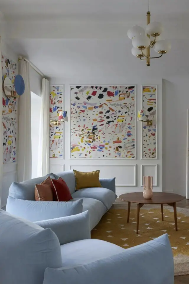 décoration intérieure bleu ciel photo salon chic canapé coloré papier peint motif abstrait multicolore encadré par des moulures murales coussin terracotta et jaune ocre tapis table basse en bois décoration intérieure bleu ciel photo salon chic canapé coloré papier peint motif abstrait multicolore encadré par des moulures murales coussin terracotta et jaune ocre tapis table basse en bois