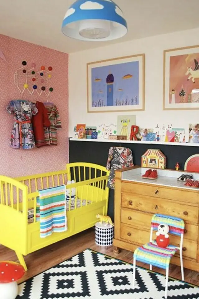 chambre bébé déco vintage lit rétro à barreaux relookés jaune table à langer commode en bois tapis noir et blanc moderne mur accent rose 