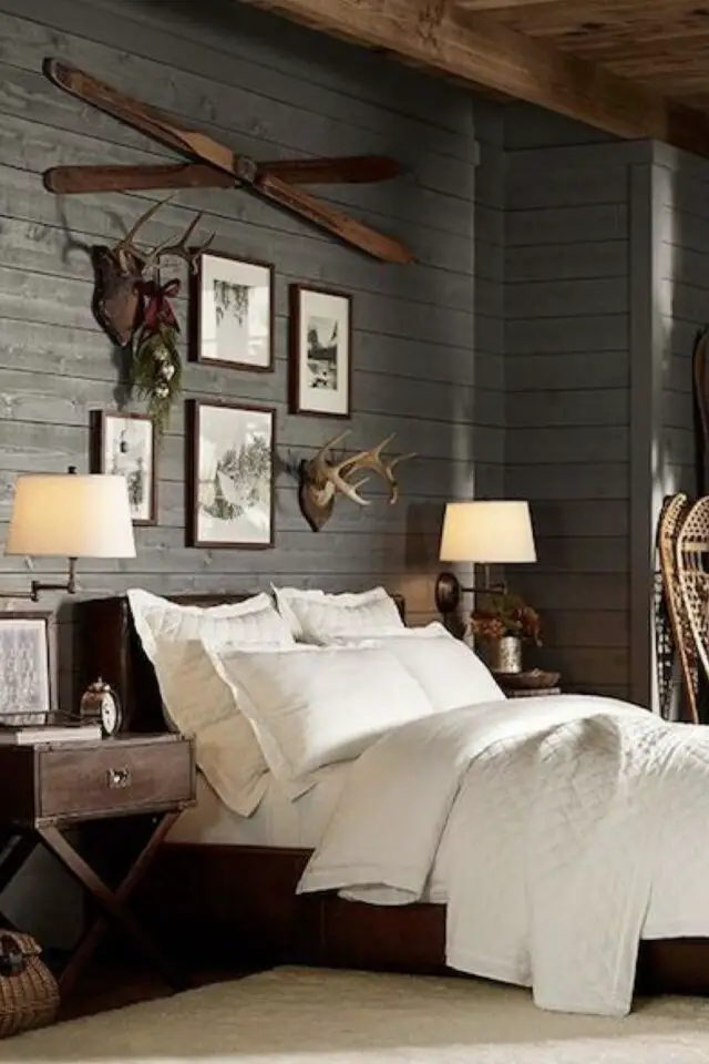 chambre déco chalet rustique chic ambiance élégante lambris foncé bois poutre cadres appliques murales tapis XXL sous le lit draps blancs 