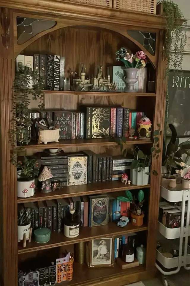 décoration bibliothèque style cottage cosy meuble rangement en bois patiné et sculpté mur vert petites plantes vertes idée déco à copier cottage-core décoration bibliothèque style cottage cosy meuble rangement en bois patiné et sculpté mur vert petites plantes vertes idée déco à copier cottage-core