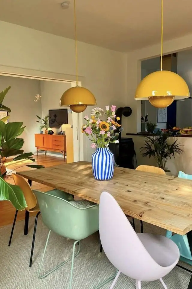 salle à manger en bois décoration chaleureuse touche personnelle moderne vase rayé bleu et blanc chaises dépareillées suspension design jaune 