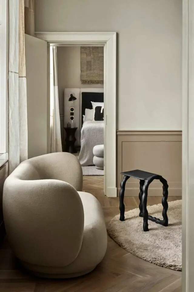 camaïeu beige décoration soubassement moulure discrète mur blanc écru canapé moderne arrondi tapis poils longs 