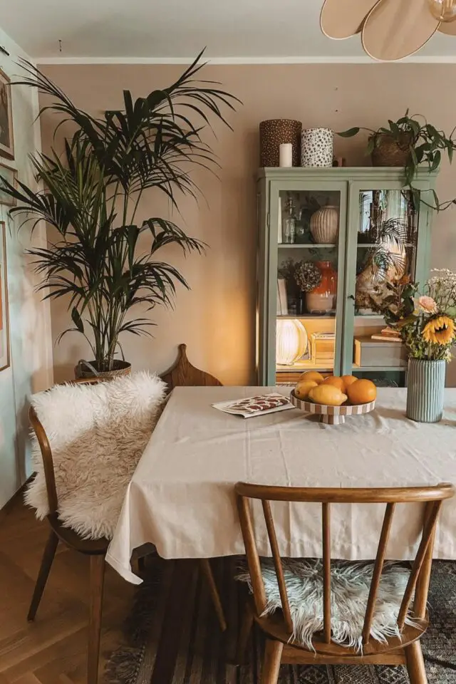 plante bien être hiver décoration intérieure salle à manger cosy nappe naturelle chaises en bois vaisselier vitrine verte mur beige 