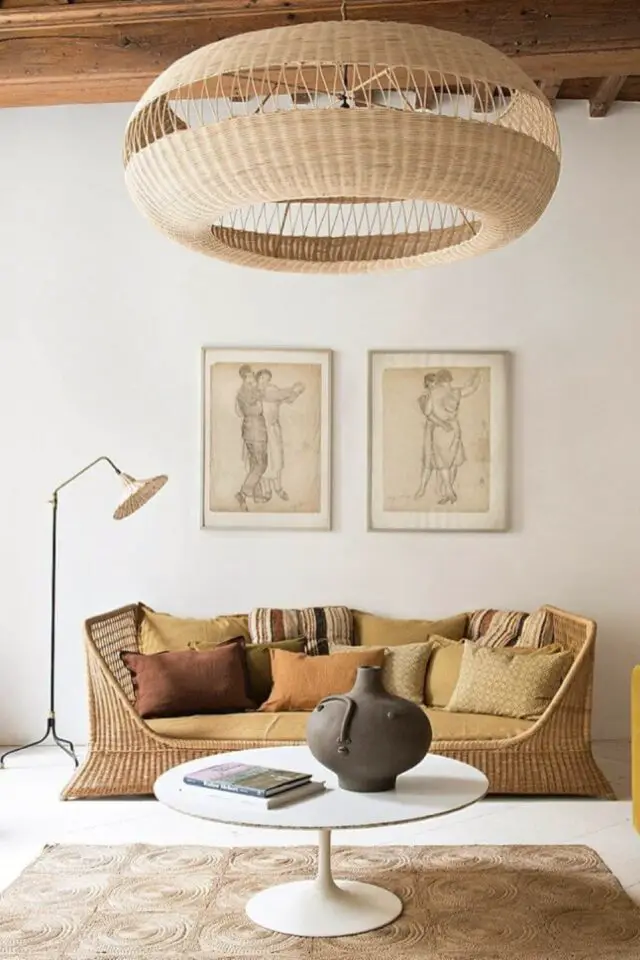 salon bohème estival meuble en rotin chic et design canapé original coussin couleur chaude et organique ocre marron déco mur épurée 