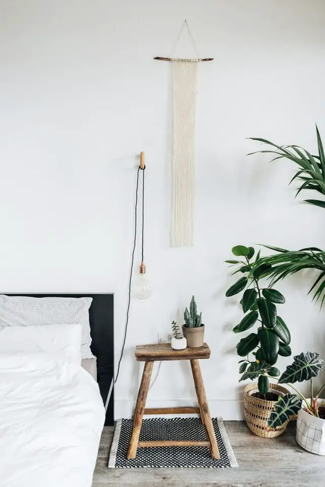 décoration chambre parentale style urban jungle minimaliste mur blanc tabouret bois plantes vertes 