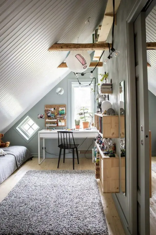 chambre mansardée d'un côté espace enfant lambris bois peint en blanc lit sous la pente bureau devant la fenêtre étagère murale rangement jouets 