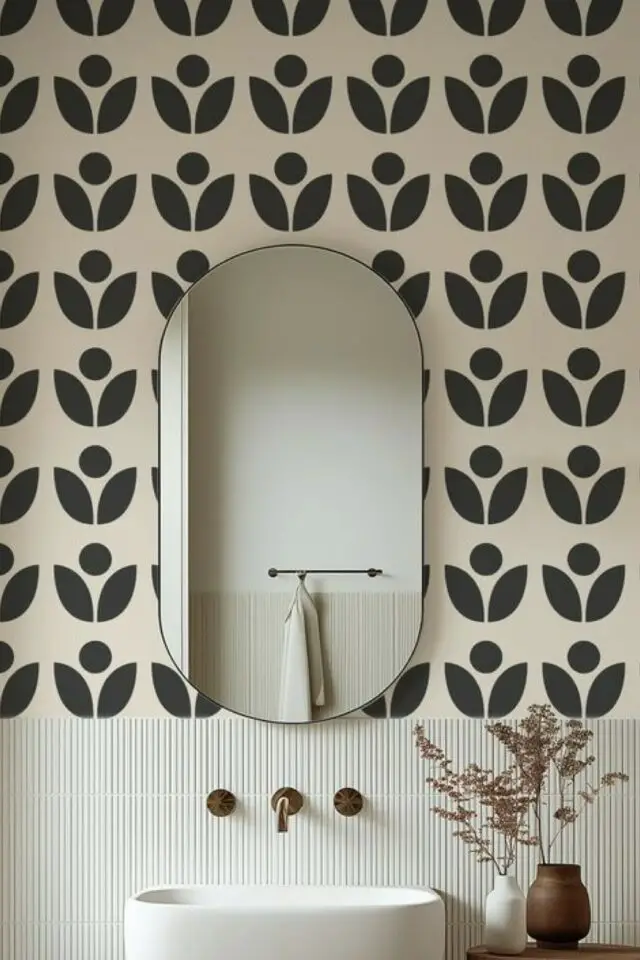 papier peint motif graphique posé au dessus soubassement carrelage décor élégant et chic miroir ovale encadrement fin noir déco salle de bain mur 