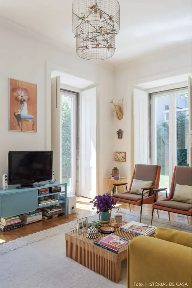 Idée déco salon appartement moderne et coloré fauteuil vintage canapé jaune meuble TV bleu mur blanc table basse texturée Idée déco salon appartement moderne et coloré fauteuil vintage canapé jaune meuble TV bleu mur blanc table basse texturée