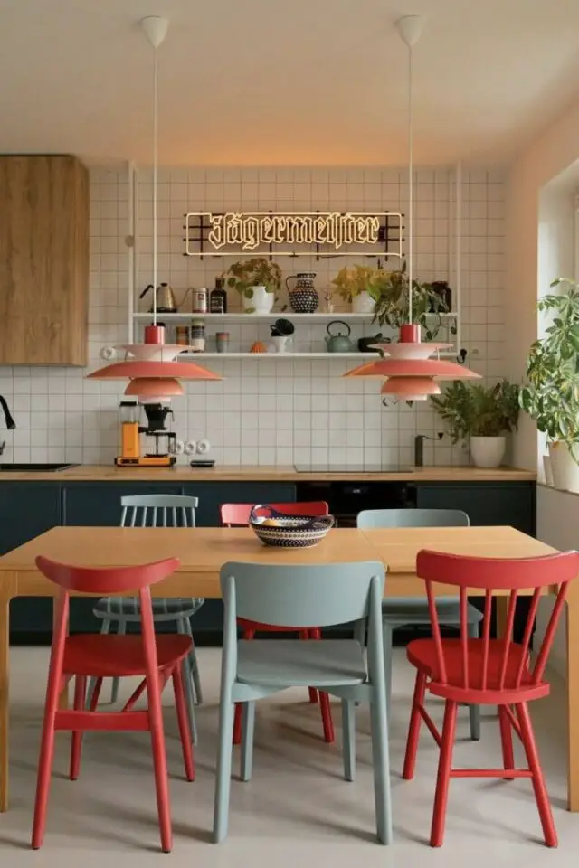 déco de cuisine simple et moderne en liénaire ouverte salle à manger table en bois chaises colorées rouge et gris luminaire suspension design orange étagère murale et néon publicitaire marque alcool déco de cuisine simple et moderne en liénaire ouverte salle à manger table en bois chaises colorées rouge et gris luminaire suspension design orange étagère murale et néon publicitaire marque alcool
