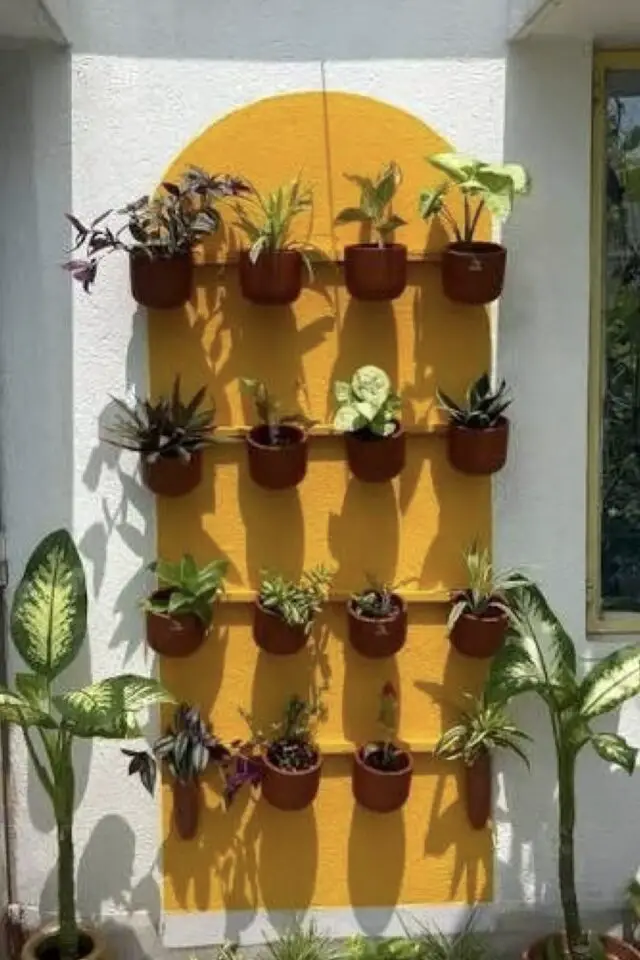 mur terrasse en brique peinture arche jaune sur fond blanc tasseaux peints pour accrocher des pots de fleurs en terre-cuite mur terrasse en brique peinture arche jaune sur fond blanc tasseaux peints pour accrocher des pots de fleurs en terre-cuite