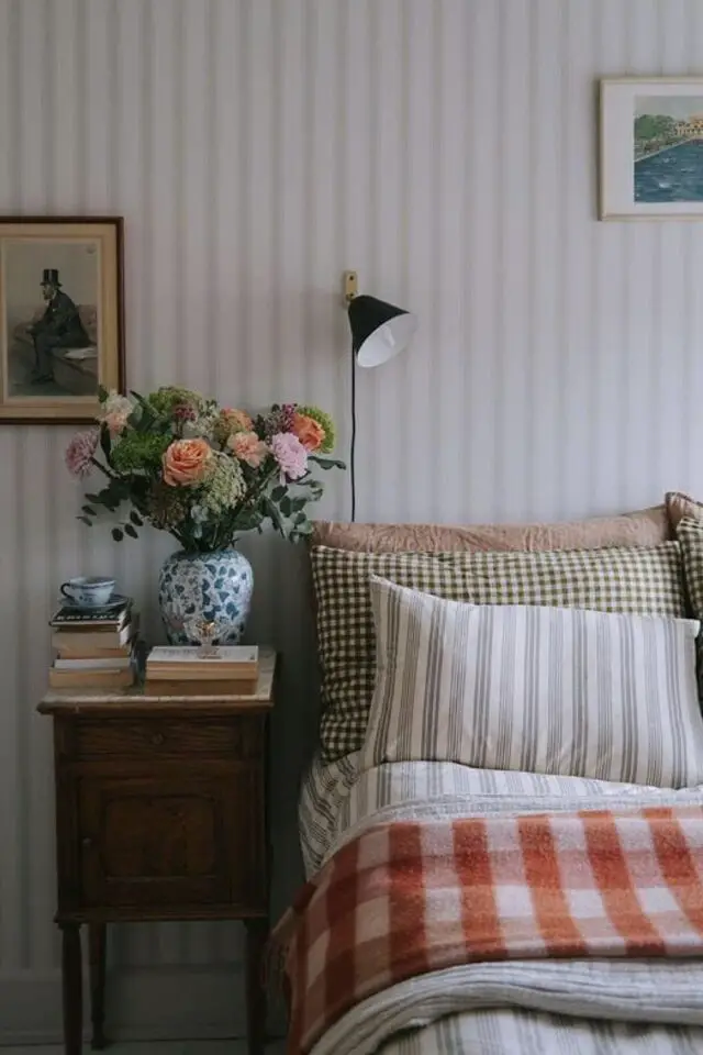 décoration chambre campagne chic papier peint rayé linge de lit carreaux rayures table de nuit ancienne bouquet de fleurs livres 