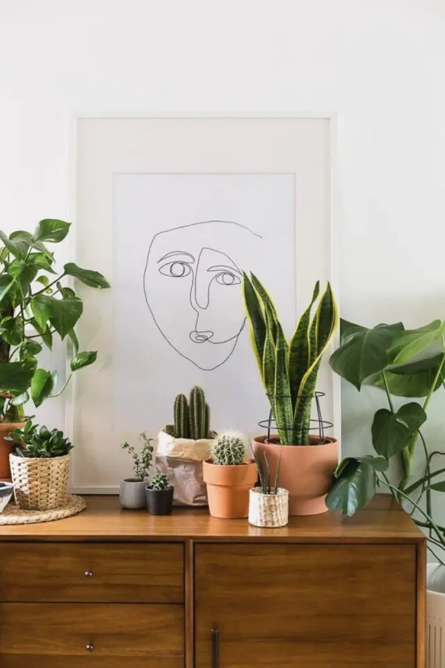 idée déco buffet de salon style urban jongle mix plantes vertes et meuble vintage en bois affiche line art encadrée 