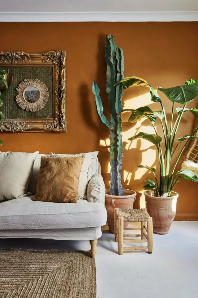 décorer le salon style urban jungle modern couleur mur ocre plante verte et cactus en pot canapé gris ambiance chaleureuse 