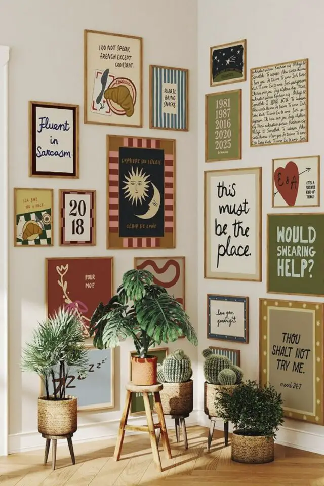 déco murale art coin de salon mélange éclectique d'affiches encadrées et petites plantes vertes posées au sol 