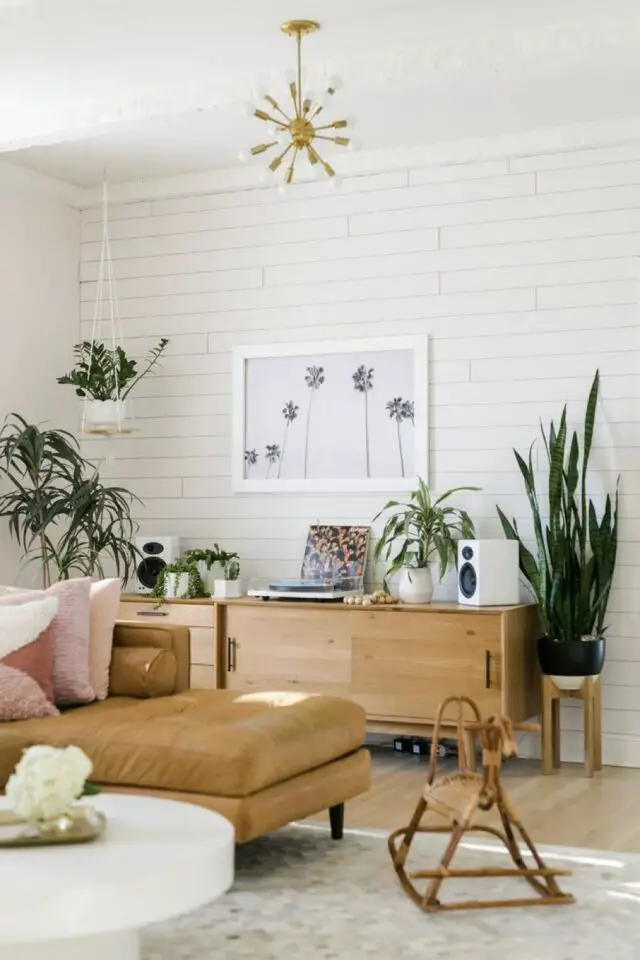 enfilade avec porte coulissante salon meuble en bois chaleureux canapé cuir plante verte revêtement mural lambris 