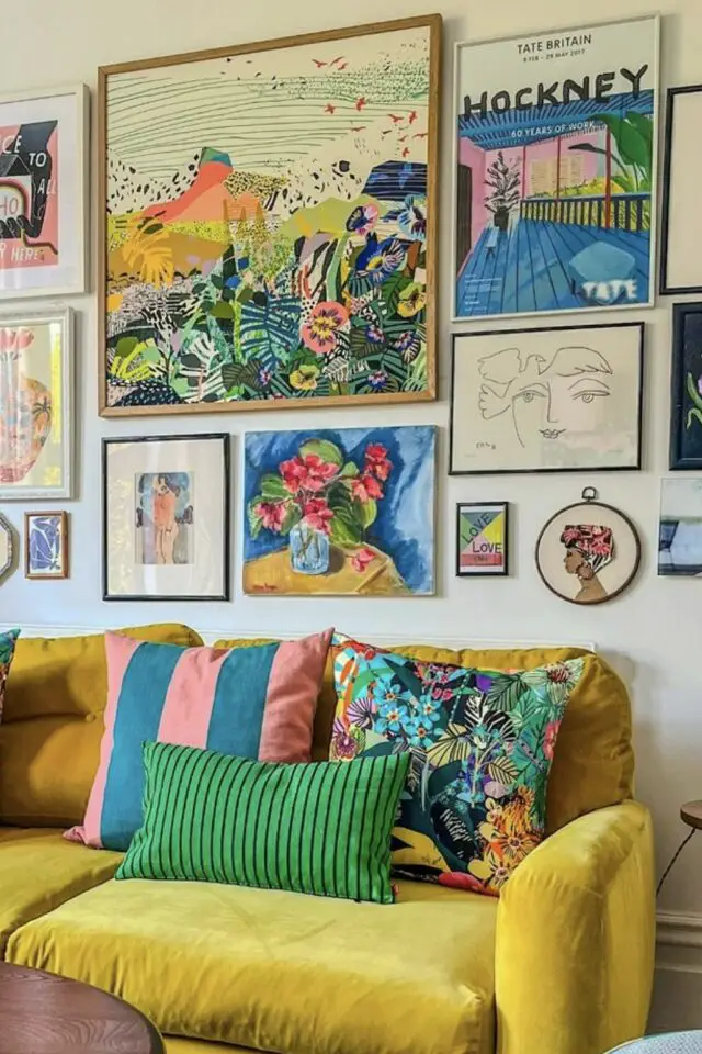 idée déco relooking salon séjour canapé jaune galerie murale tableaux colorés coussins modernes rayures velours motifs 