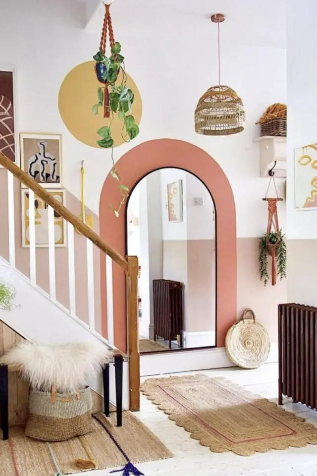 idée décoration hall d'entrée avec escaliers ouvert couleur blanc dominant soubassement rose et arche corail ambiance moderne 