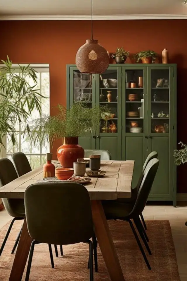 salle à manger chaleureuse mariage de couleurs terracotta peinture murale et vert meuble vitrine et chaise table en bois ambiance earthy salle à manger chaleureuse mariage de couleurs terracotta peinture murale et vert meuble vitrine et chaise table en bois ambiance earthy