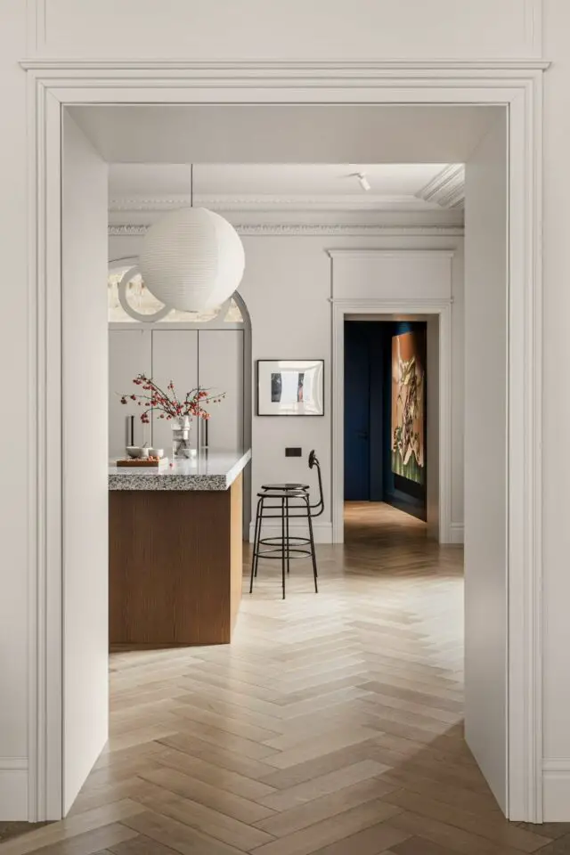 espace cuisine blanc chaleureux moderne et minimaliste espace ouvert îlot central tabouret noir parquet massif espace cuisine blanc chaleureux moderne et minimaliste espace ouvert îlot central tabouret noir parquet massif