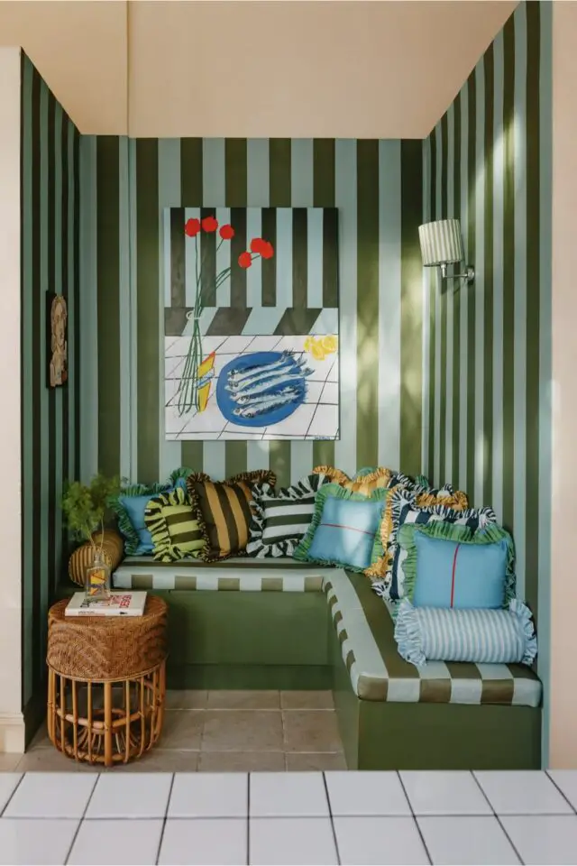 Coin lecture banquette vert olive et bleu pastel papier peint à rayures coussins maximalisme 