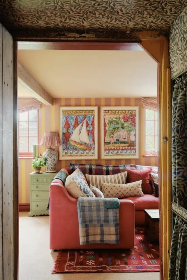 décorer le salon dans le style whimsical caractéristiques papier peint rayé couleur pastel affiche illustration ancienne canapé rose coussins motifs éclectiques tapis coloté 