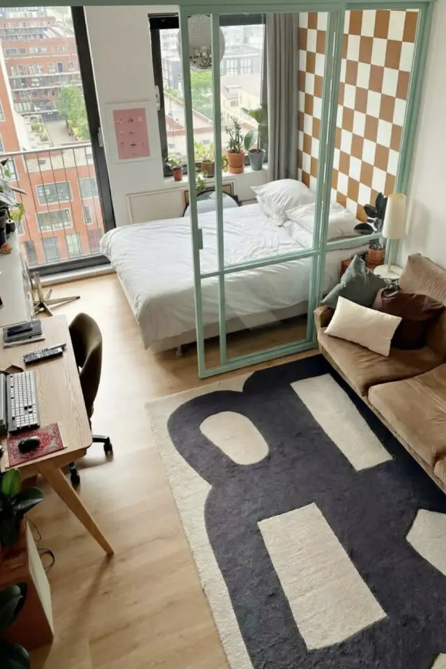 propriétaire appartement étudiant moderne verrière coulissante séparation chambre et salon papier peint damier canapé en velours tapis design noir et beige bureau en bois propriétaire appartement étudiant moderne verrière coulissante séparation chambre et salon papier peint damier canapé en velours tapis design noir et beige bureau en bois