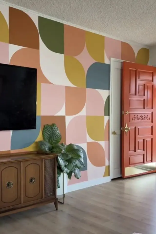 mur accent salon derrière écran tv papier peint motif vintage coloré arrondi quart de cercle rose vert ocre orange corail 