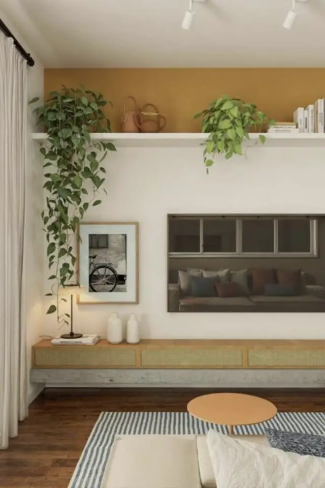 déco de salon facile touche de couleur peinture jaune haut du mur séparation avec une longue étagère blanche détail déco au dessus de l'écran de télé plantes vertes  