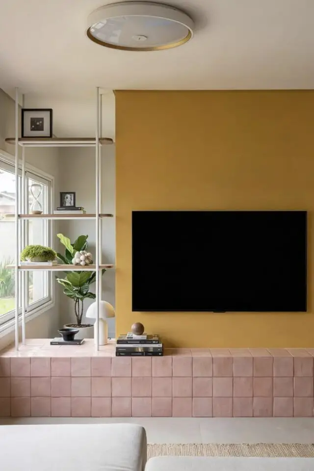 inspiration déco salon mur accent TV peinture jaune et soubassement carrelage rose vintage association de couleur moderne étagère blanche idée simple à copier 