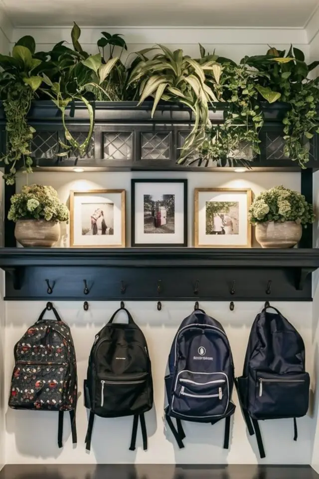 toute petite entrée déco patères murale étagères cadres photo de famille posé plantes sacs d'école suspendus 