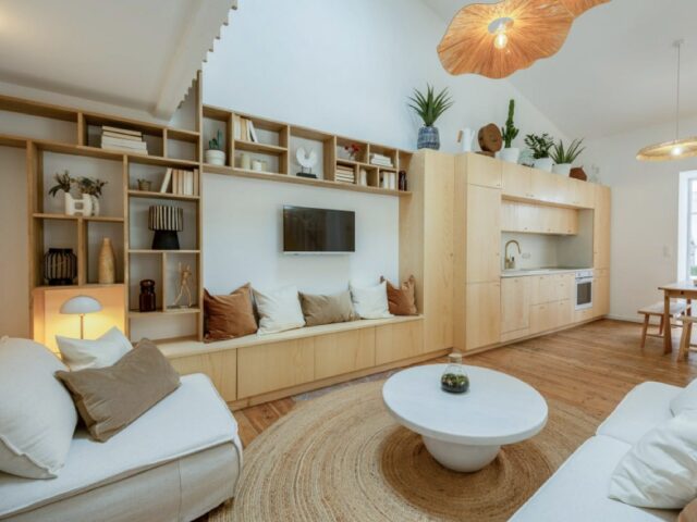 Mur TV avec bibliothèque sur mesure prolongement meuble cuisine en linéaire grande hauteur sous plafond cadre intime et chaleureux salon 