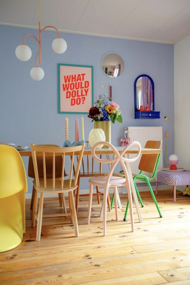 salle à manger style whimsical mur bleu pastel table en bois chaises design dépareillées 