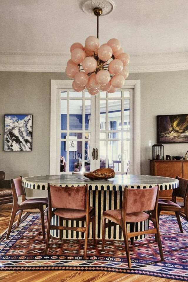 salle à manger table ovale à rayure chaises en velours rose et suspension originale 