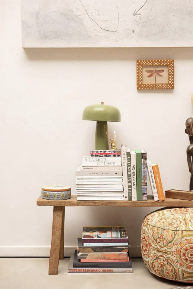 Petite lampe champignon vert sauge posée sur une pile de livre et un banc en bois salon cosy moderne Petite lampe champignon vert sauge posée sur une pile de livre et un banc en bois salon cosy moderne