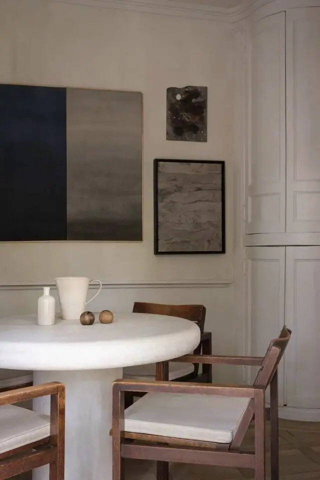 petite table ronde moderne blanche salle à manger minimaliste chic chaleureuse tableau au mur chaises fauteuil en bois 