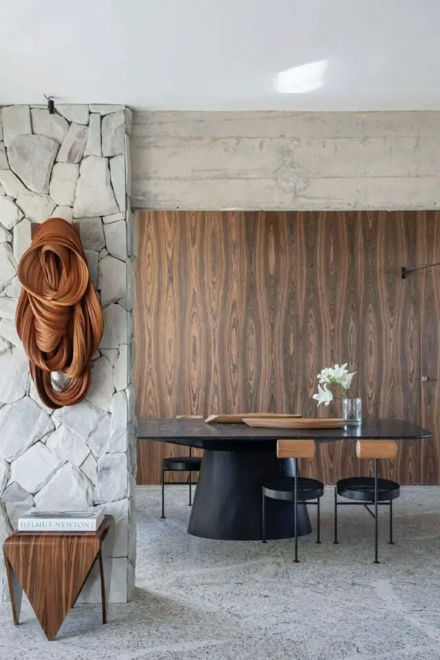 table ronde noire salle à manger mur en bois sombre sol terrazzo gris chaise design ambiance chic et chaleureuse 