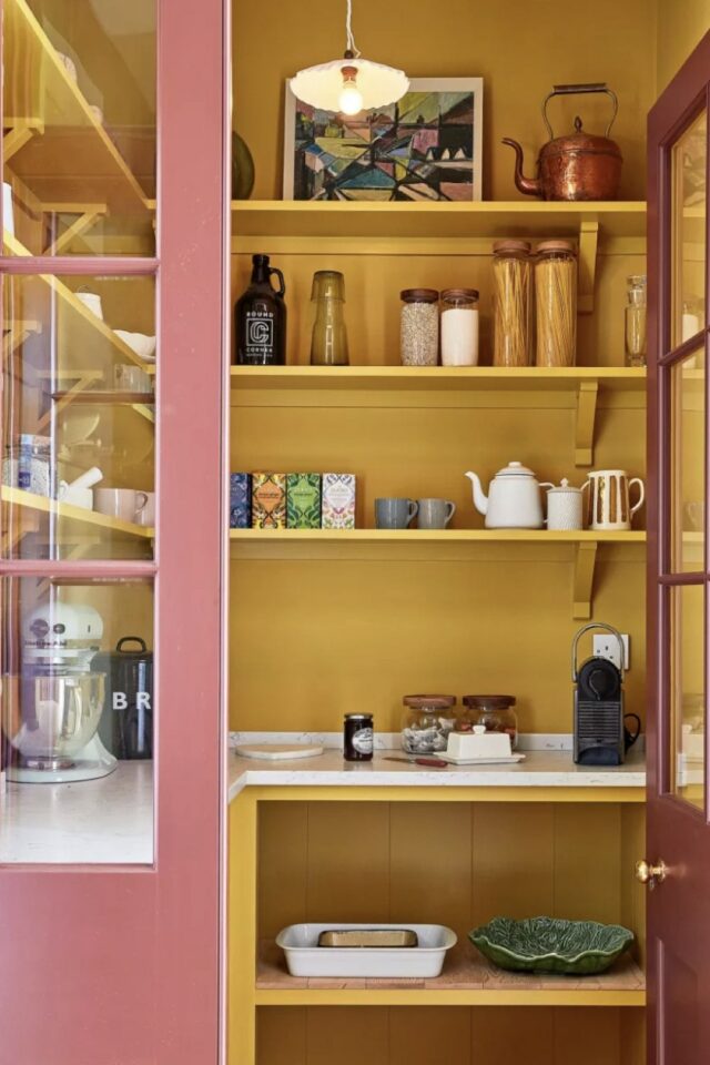 petite arrière-cuisine colorée peinture jaune séparer de la cuisine avec une porte vitrée rose 