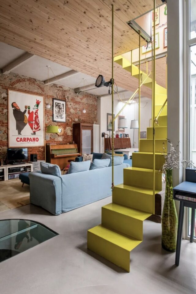 salon ouvert mur de brique escalier en métal jaune canapé bleu affiche XXL encadrée salon ouvert mur de brique escalier en métal jaune canapé bleu affiche XXL encadrée